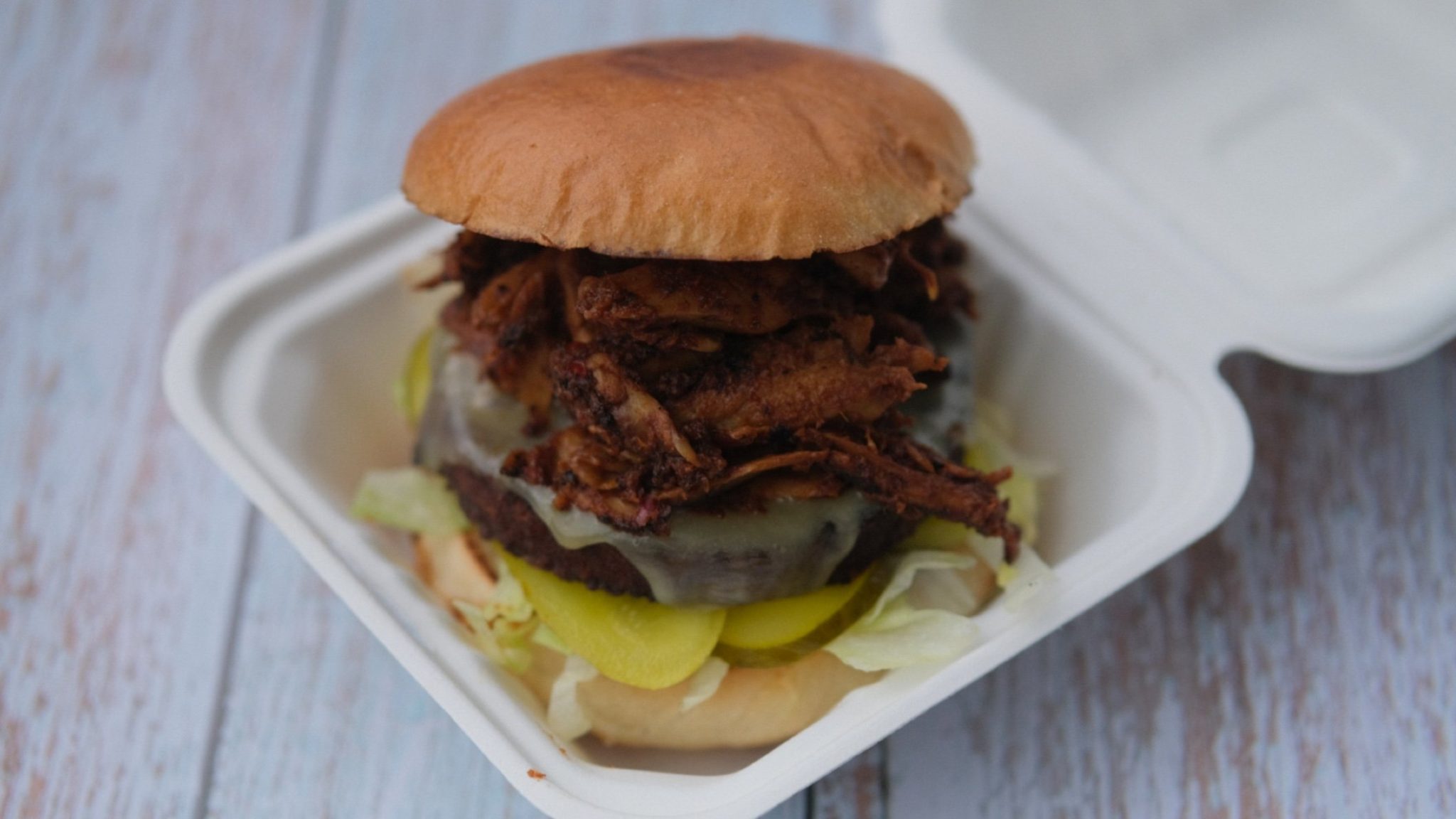 Photo of loaded vegetarian burger with veggie pulled soya, gerkins, cheese and salad