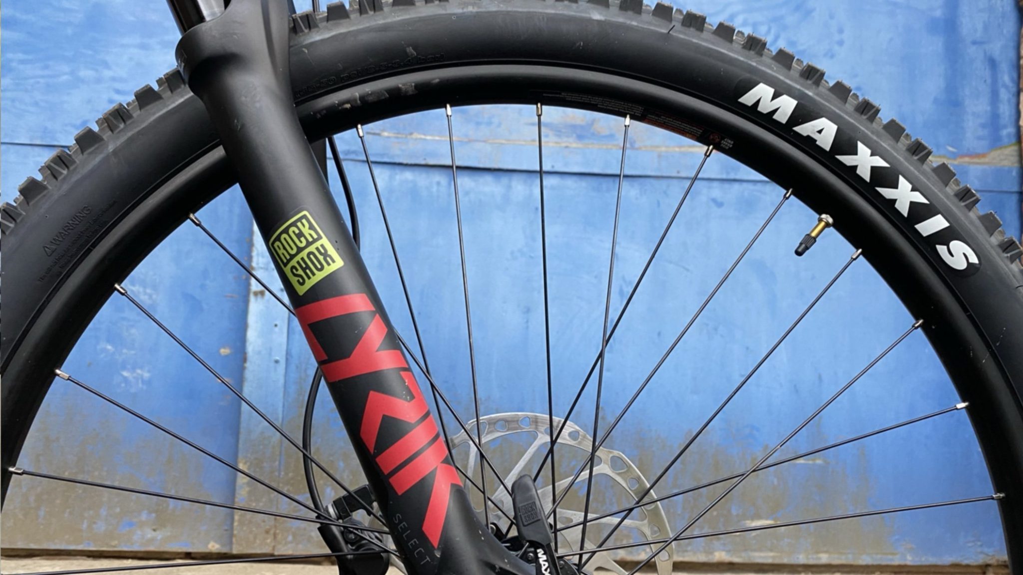 Photo of front wheel of bike showing MTB suspension forks with RockShox Lyrik written on them
