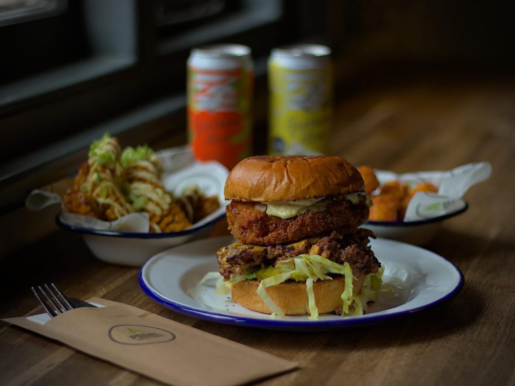 Burger and Sides on table with drinks from new summer menu