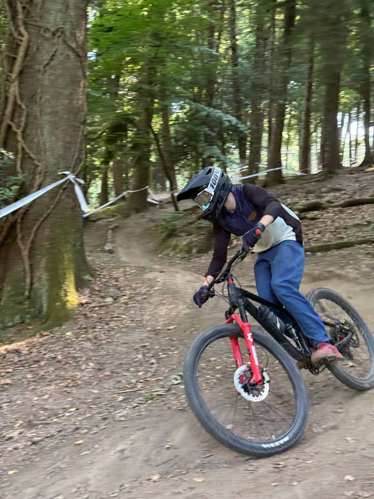 A rider on a mountain bike is doing downhill riding between race tape
