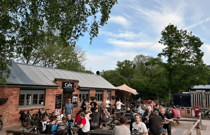 Photo of the outside of the cafe in the sunshine with people eating, drinking and chatting