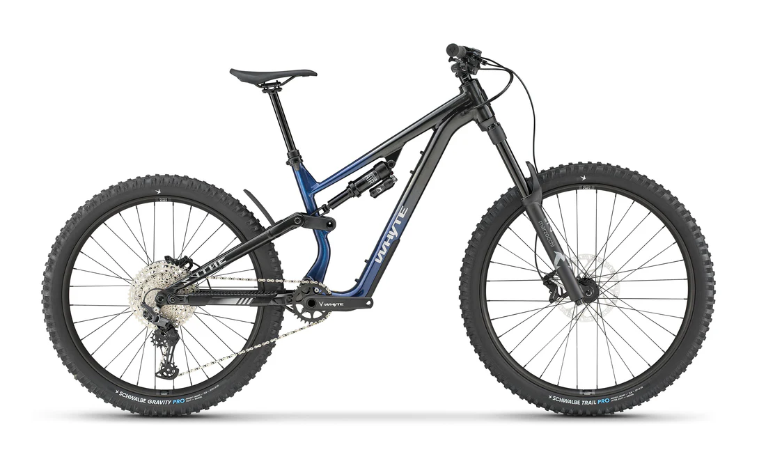 Bike Hire Orange Whyte T140 or T160 leaning on blue door.